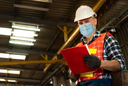 Factory Workers With Face Mask discusses shift change issues Collaboration PLUS